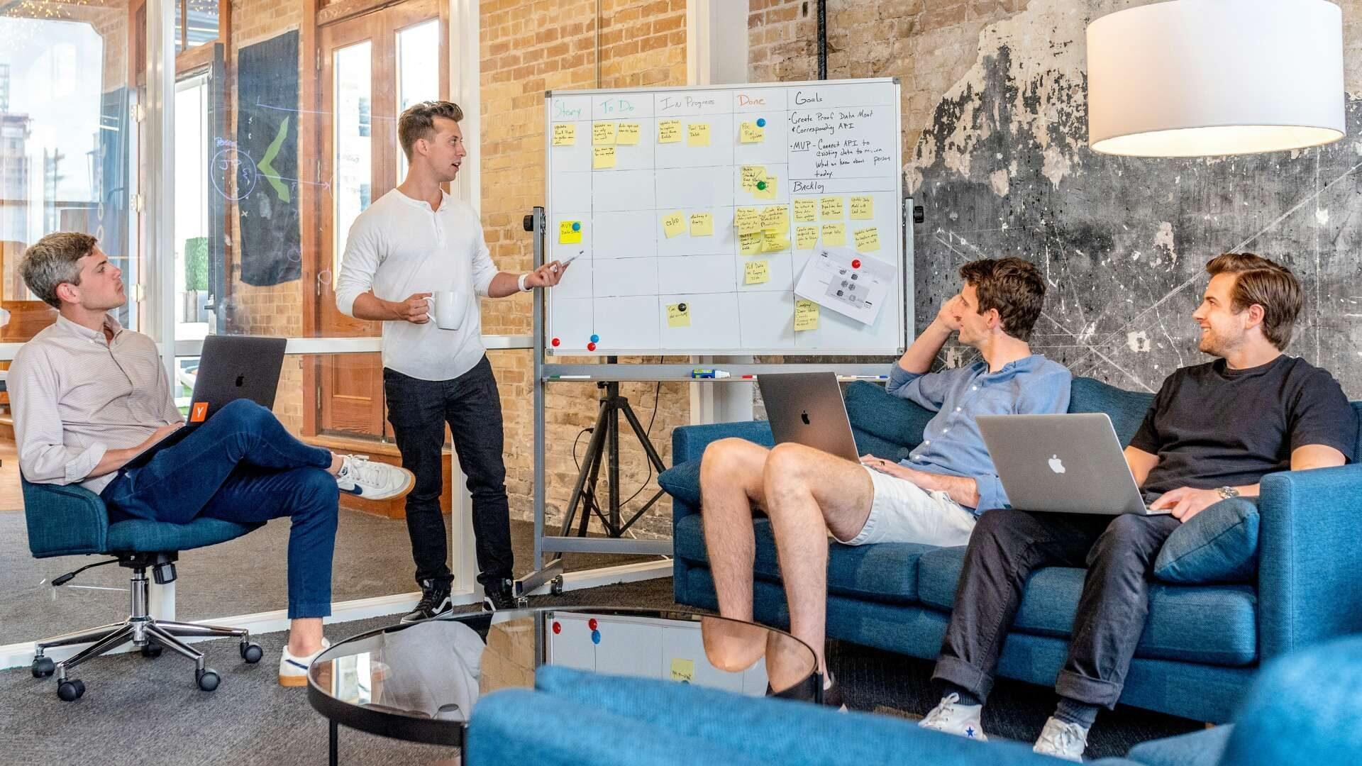 Equipe em reunião diante de quadro branco em escritório